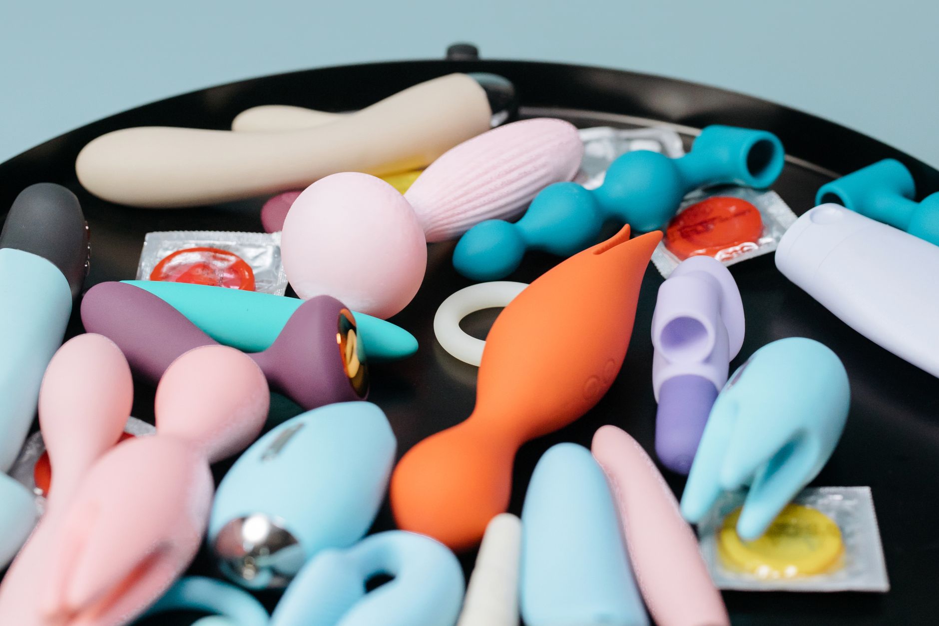 A vibrant collection of adult toys on a black tray, featuring diverse shapes and colors