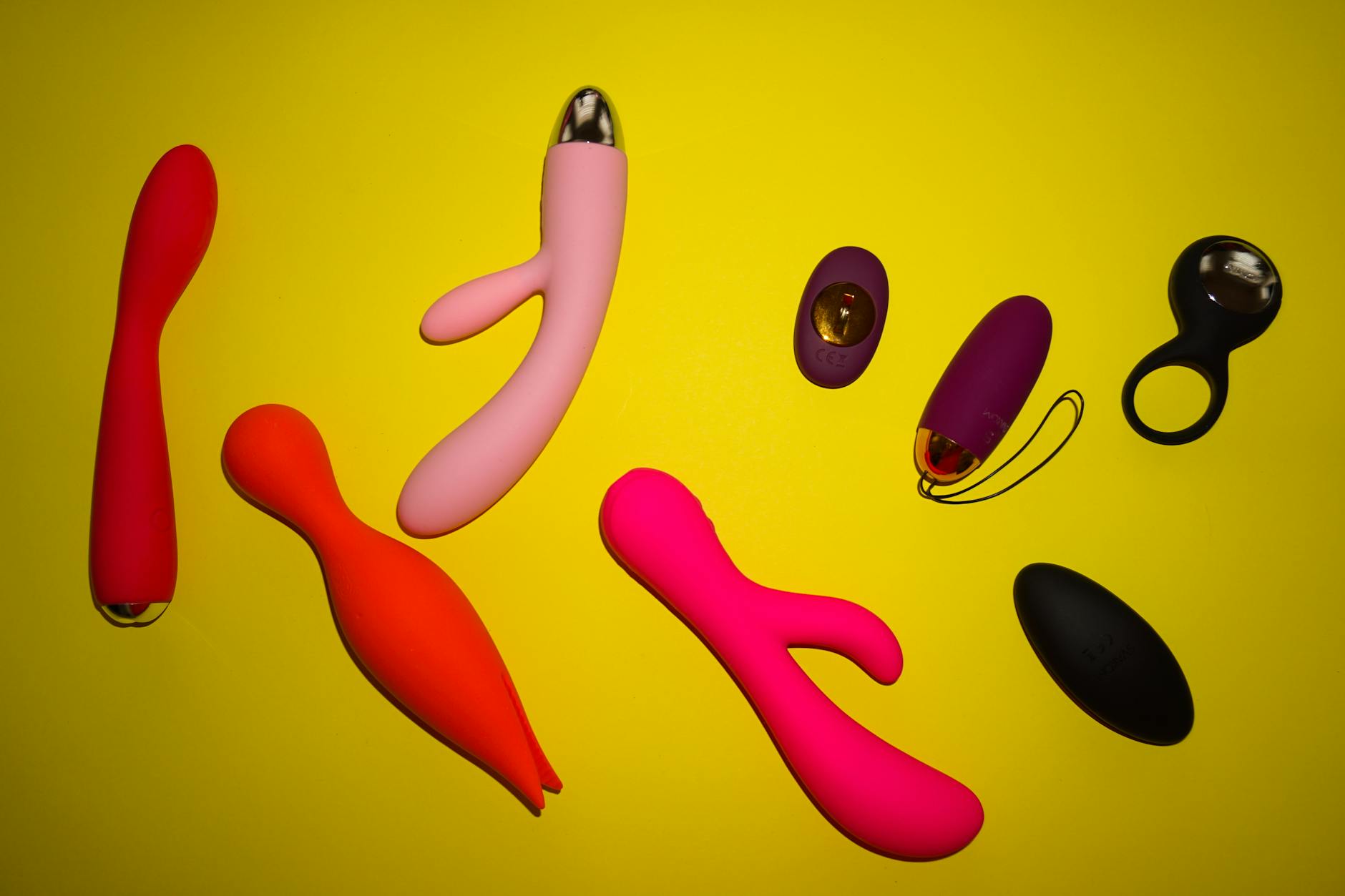 Woman holding two colorful vibrators against a purple background